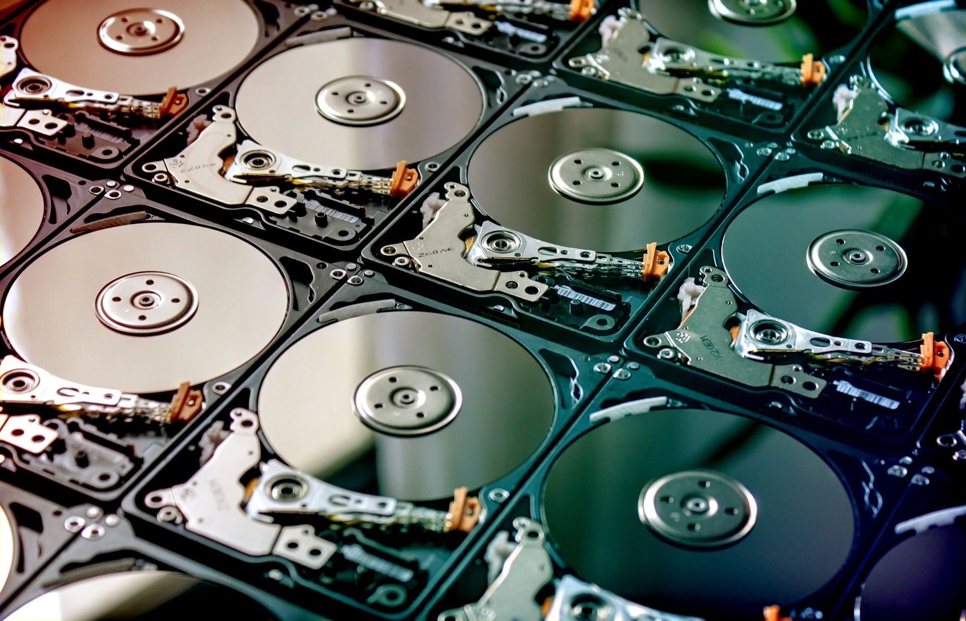 Plusieurs disques durs disposés en grille, éclairés par des tons chauds et froids.