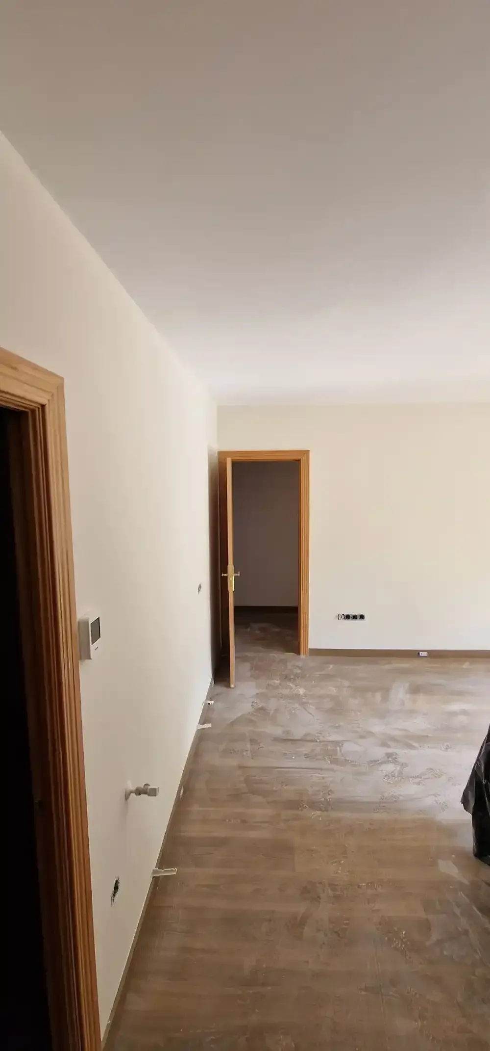 Interior en construcción, andamios, paredes sin terminar, lona azul, luz solar a través de las ventanas.