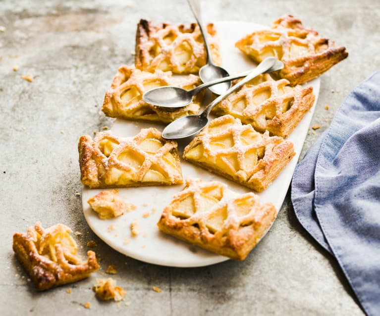 Pâtisseries aux pommes en treillis sur un plat blanc avec des cuillères