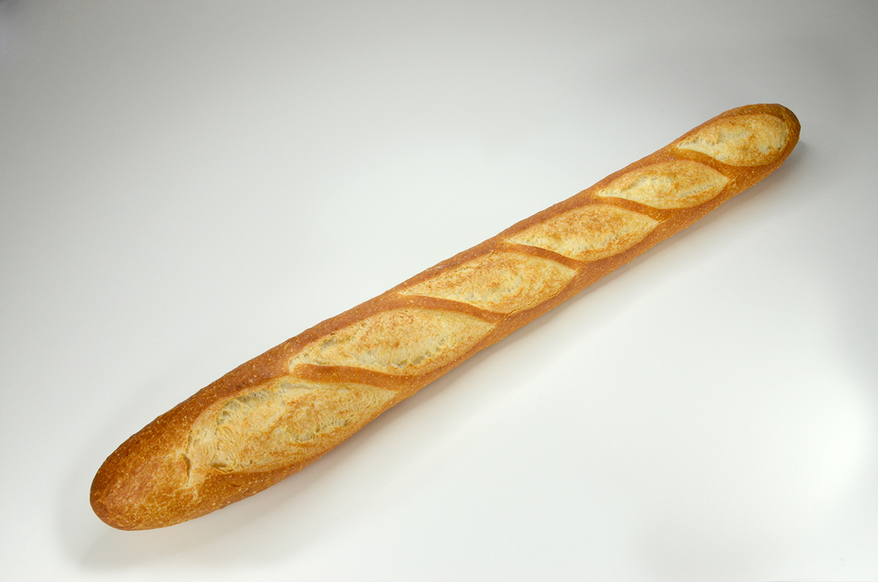 Une baguette croustillante et dorée sur une surface blanche.