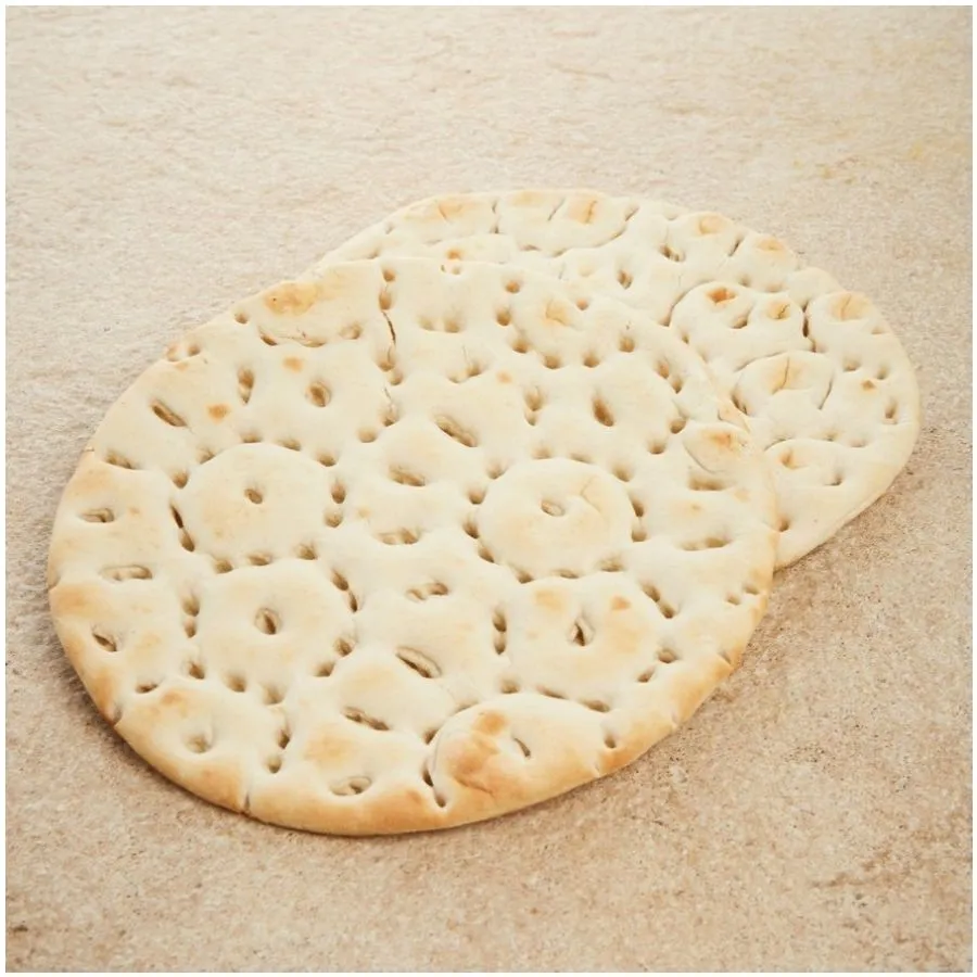 Deux pains ronds et plats, à la surface légèrement brunâtre et présentant des alvéoles.