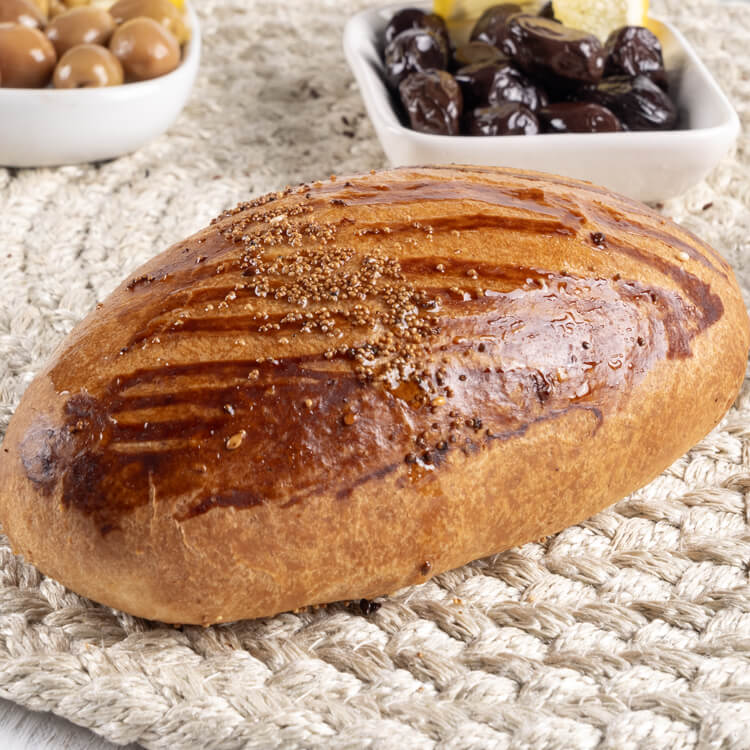 Pâtisserie salée avec des olives en arrière-plan.