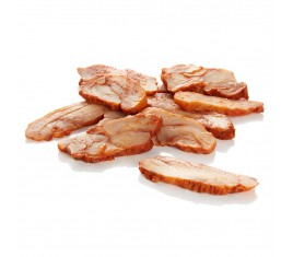 Morceaux de dinde tranchés et dorés, empilés sur une surface blanche.