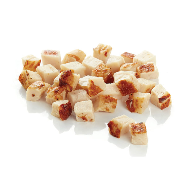 Un tas de tofu cuit et coupé en dés, aux bords dorés, sur une surface blanche.