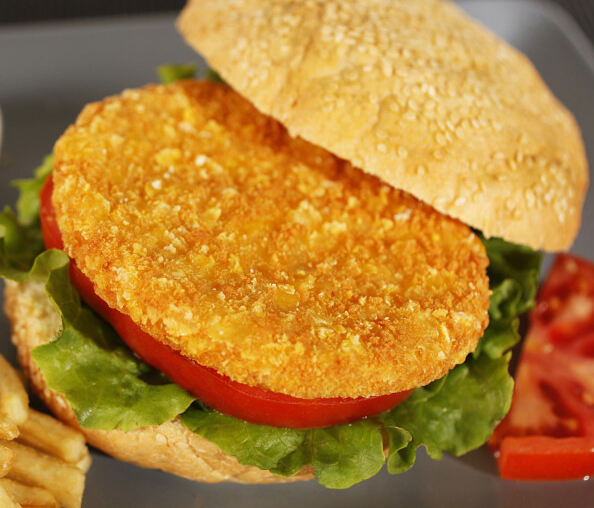 Sandwich au steak haché pané avec laitue, tomate et pain.