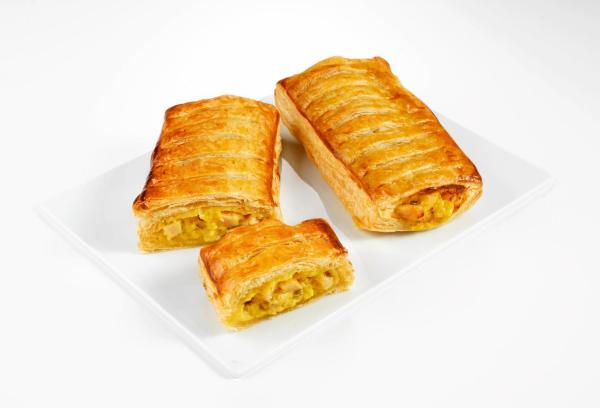 Trois pâtisseries dorées à la garniture visible, présentées sur une assiette blanche.