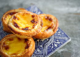 Tartelettes aux œufs, croûte dorée et garniture crémeuse, présentées en petit présentoir.