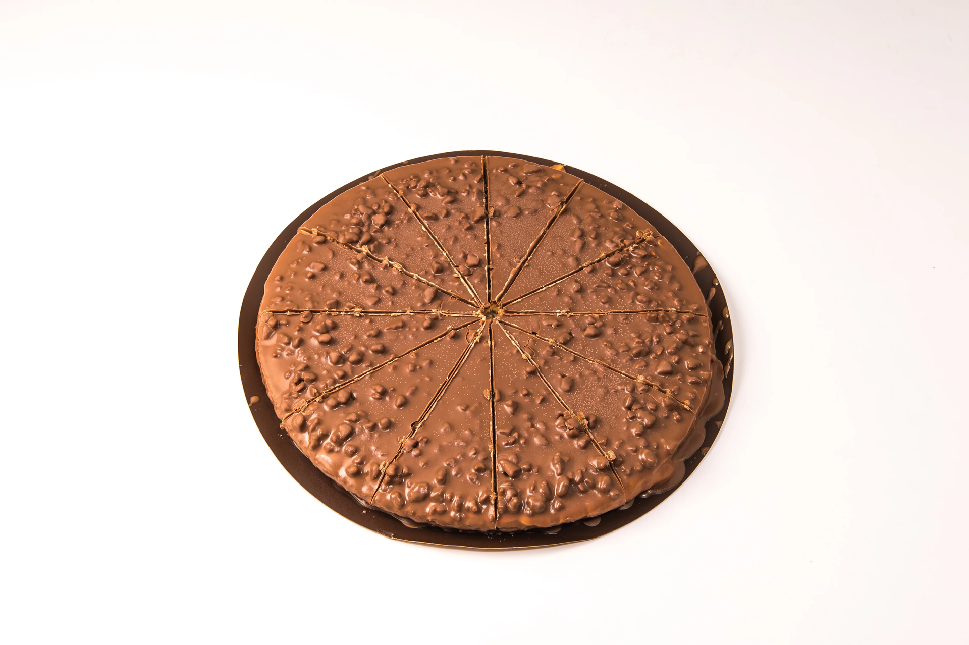 Gâteau au chocolat à la croûte texturée, coupé en tranches, sur une assiette ronde foncée.