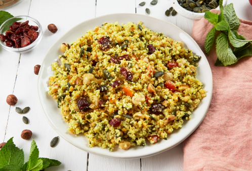 Assiette de salade de couscous aux légumes, noix et herbes.