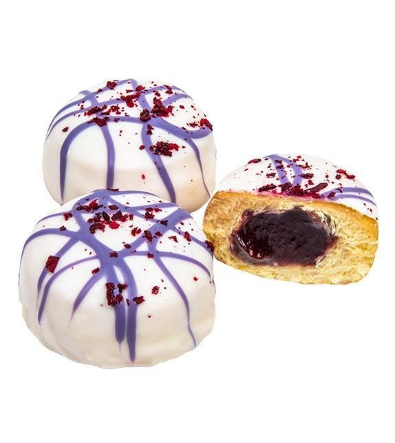 Trois pâtisseries rondes avec un glaçage blanc, un filet violet, des vermicelles rouges et une garniture foncée