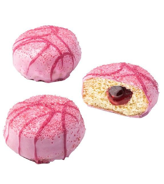 Trois pâtisseries en forme de dôme, recouvertes d'un glaçage rose, dont une ouverte révèle une garniture aux cerises.