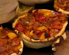 Mini-quiches fourrées de poivrons rouges et jaunes et d'oignons, dans une croûte dorée.