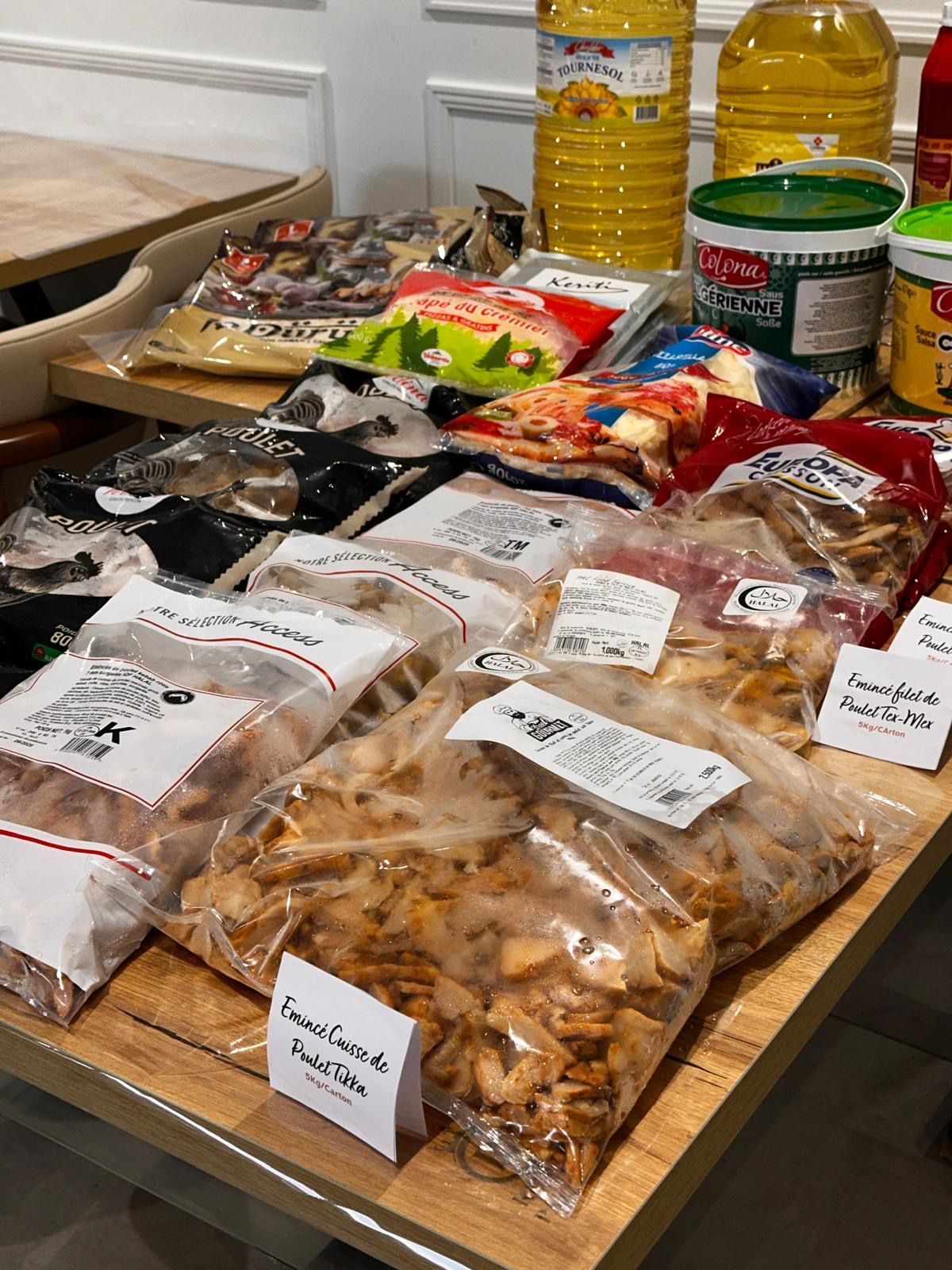 Une table sur laquelle sont posés des sacs de nourriture et des bouteilles d'huile.