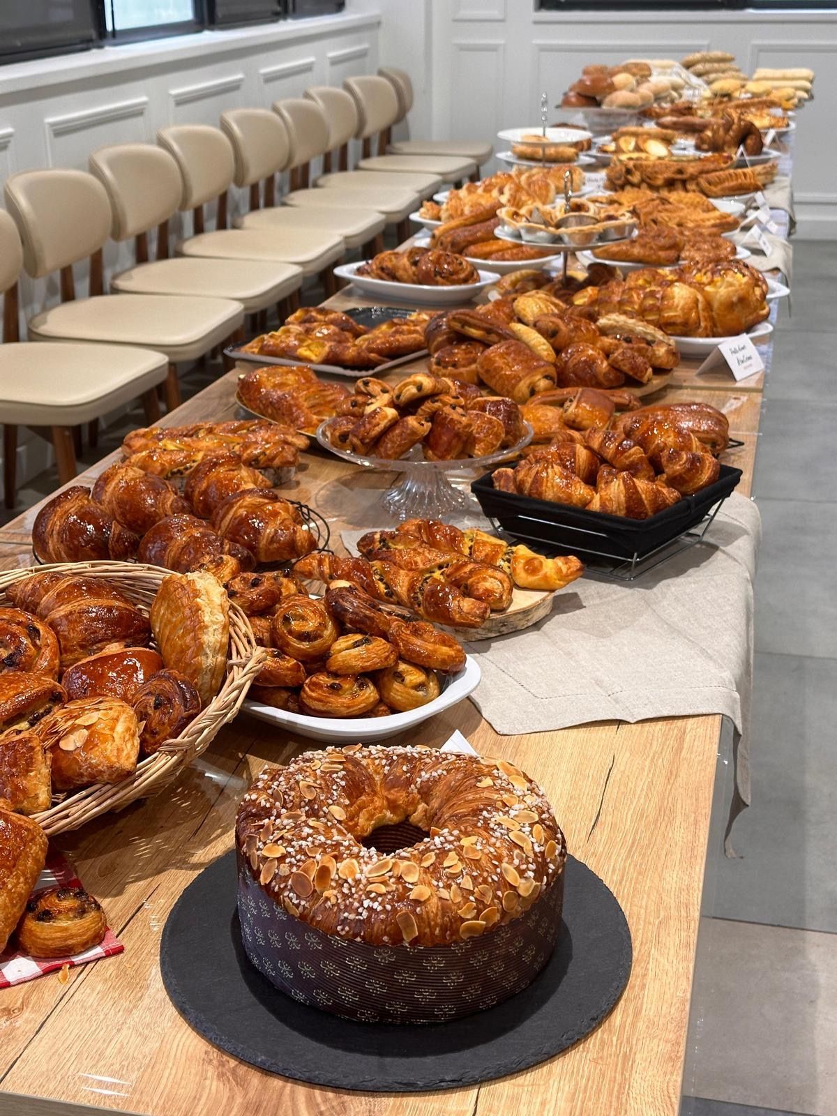 Une longue table garnie d'une variété de pâtisseries et d'un gâteau.