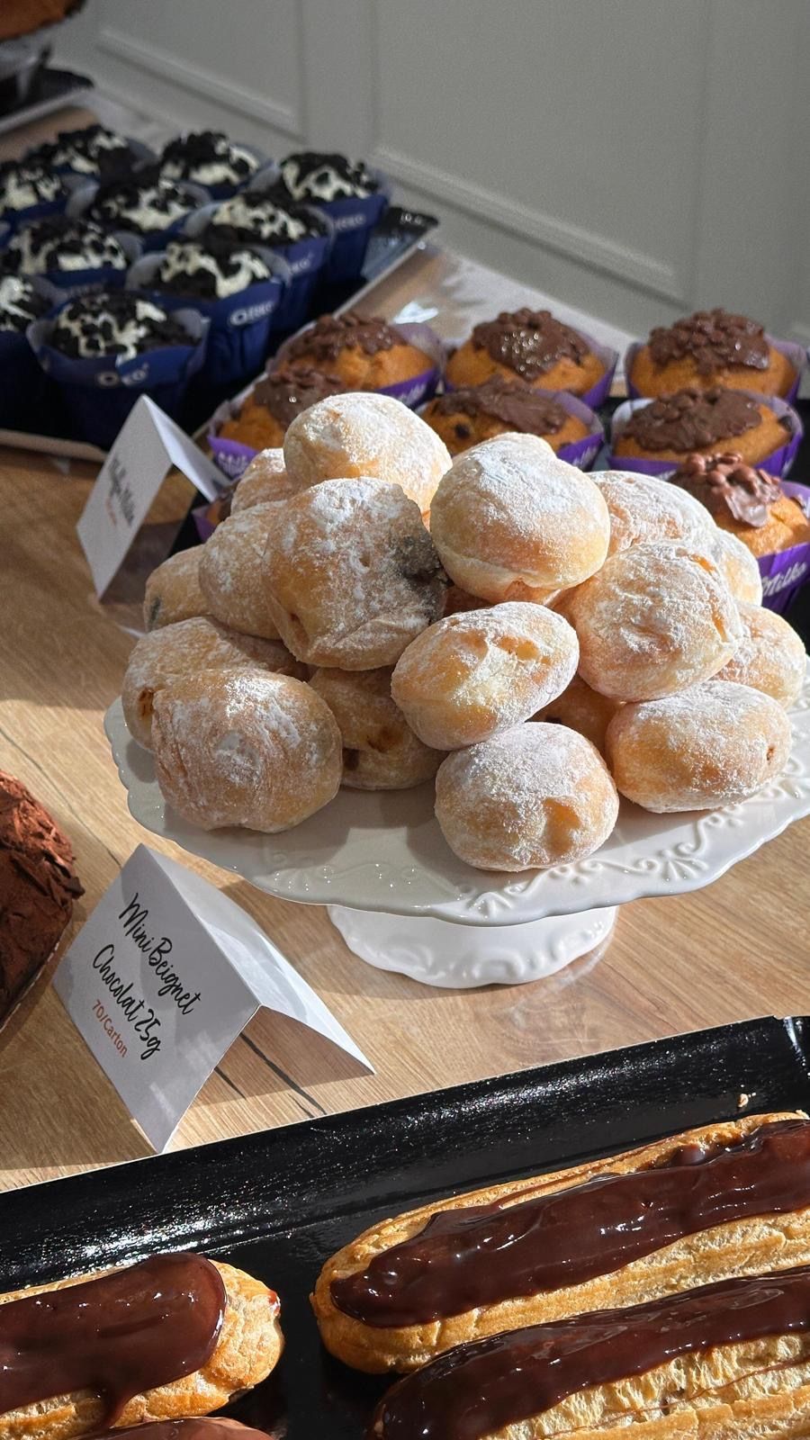 Une table garnie d'une variété de desserts, notamment des beignets et des cupcakes.