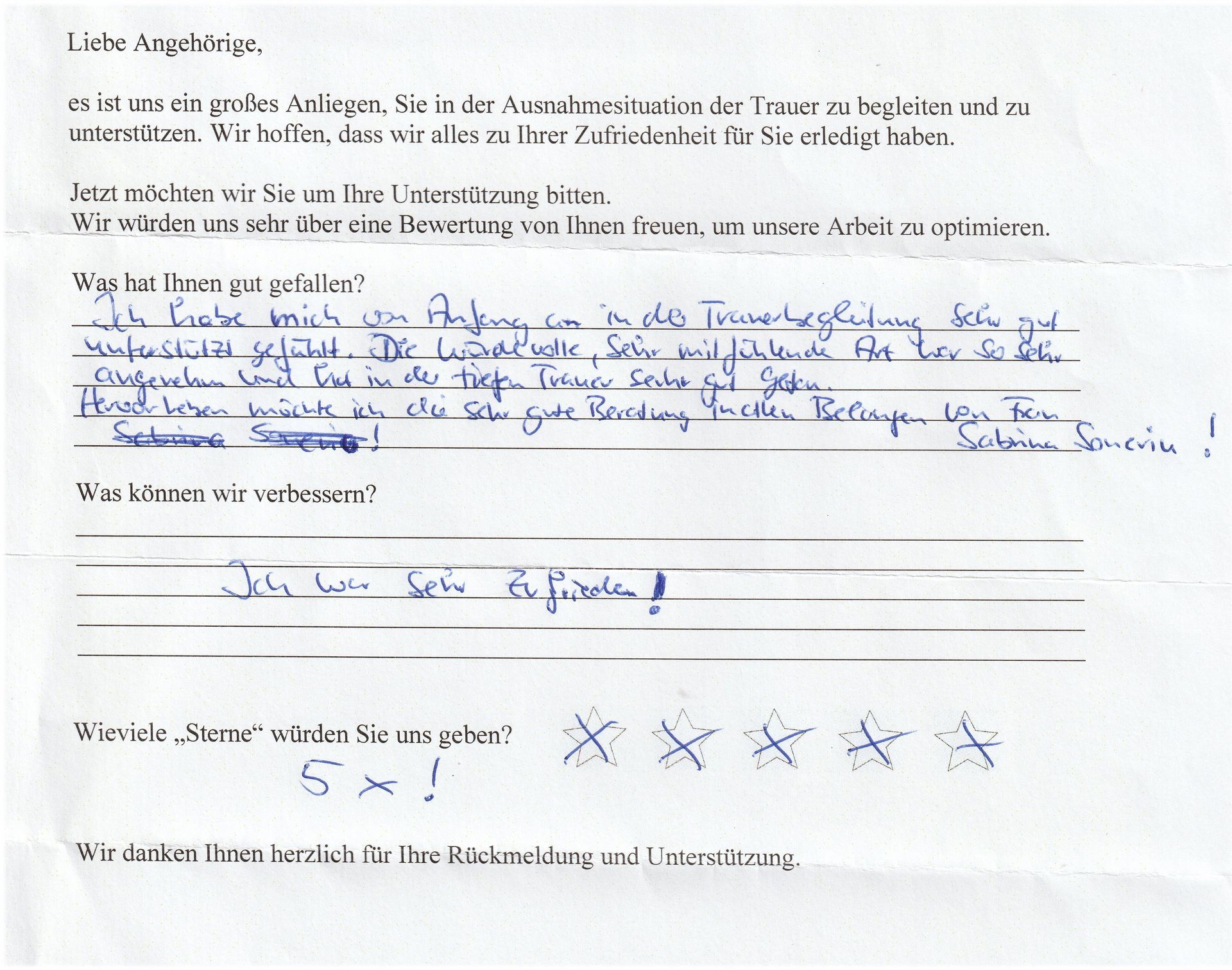 Handschriftliches Kundenfeedback auf einem Fragebogen. Eine Person vergibt 5-Sterne-Bewertungen und notiert positive Erfahrungen.