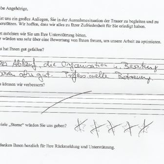 Handschriftliche Rückmeldung auf einem Formular, in der eine Trauerfeier mit vier von fünf Sternen erwähnt wird.