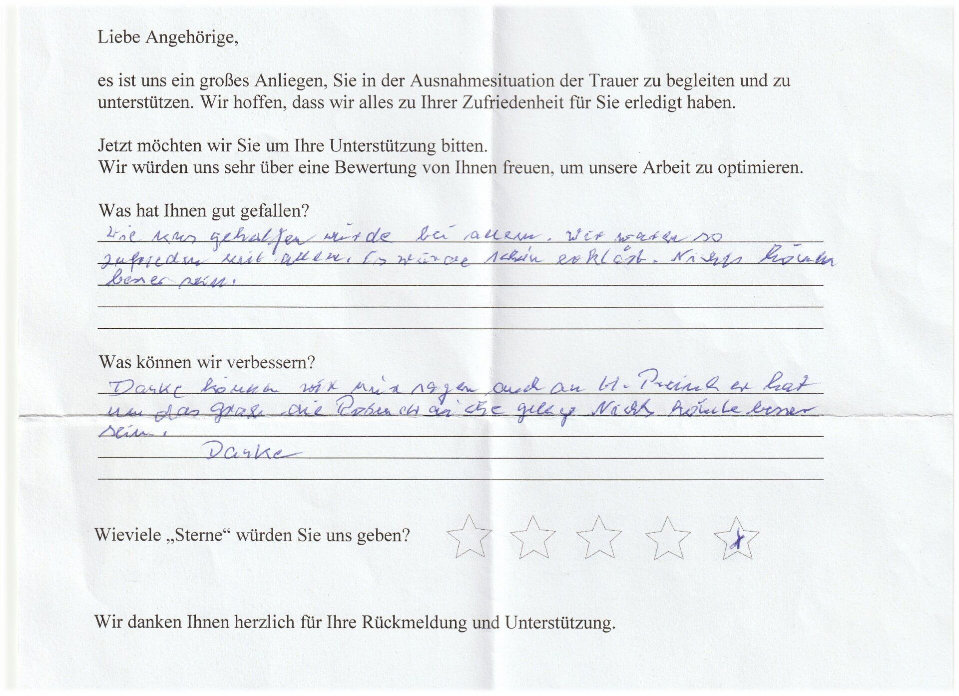 Handschriftliches Feedback auf einem Fragebogen mit blauem Stift, deutsche Sprache und einer 2-Sterne-Bewertung.