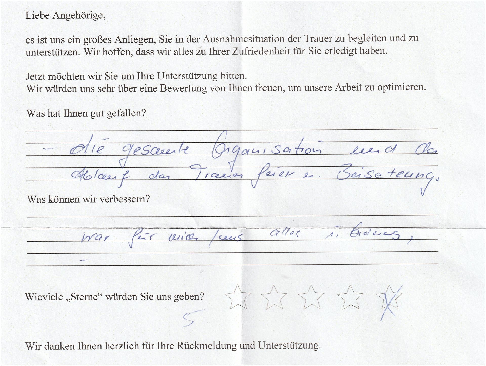 Handschriftliches deutsches Feedbackformular mit Begriffen wie „Organisation“ und mit Sternen gekennzeichneten Bewertungen.