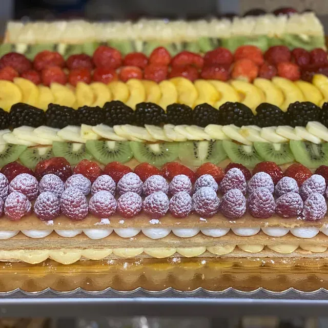 Un pastel con muchos tipos diferentes de frutas encima.