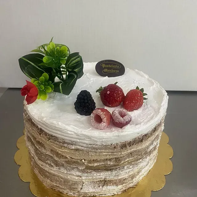 Un pastel con fresas y frambuesas encima.