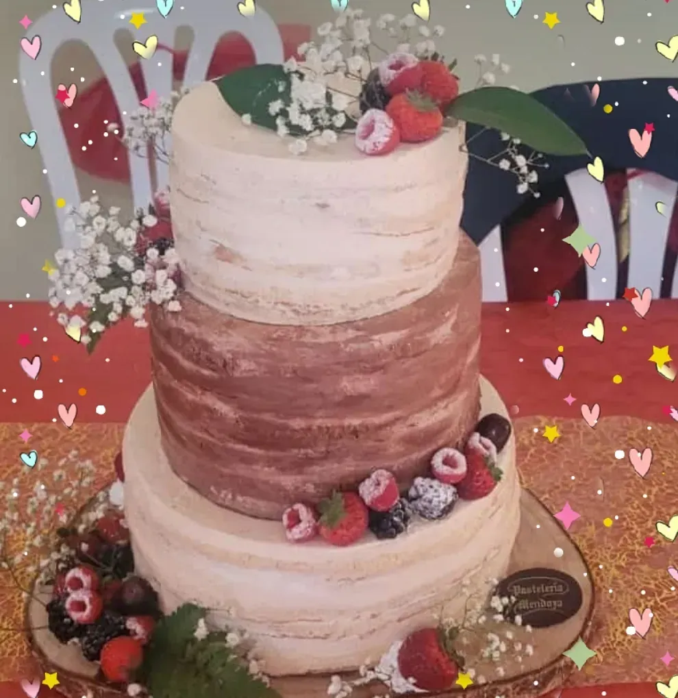 Un pastel de tres niveles con fresas y flores de aliento en la parte superior.