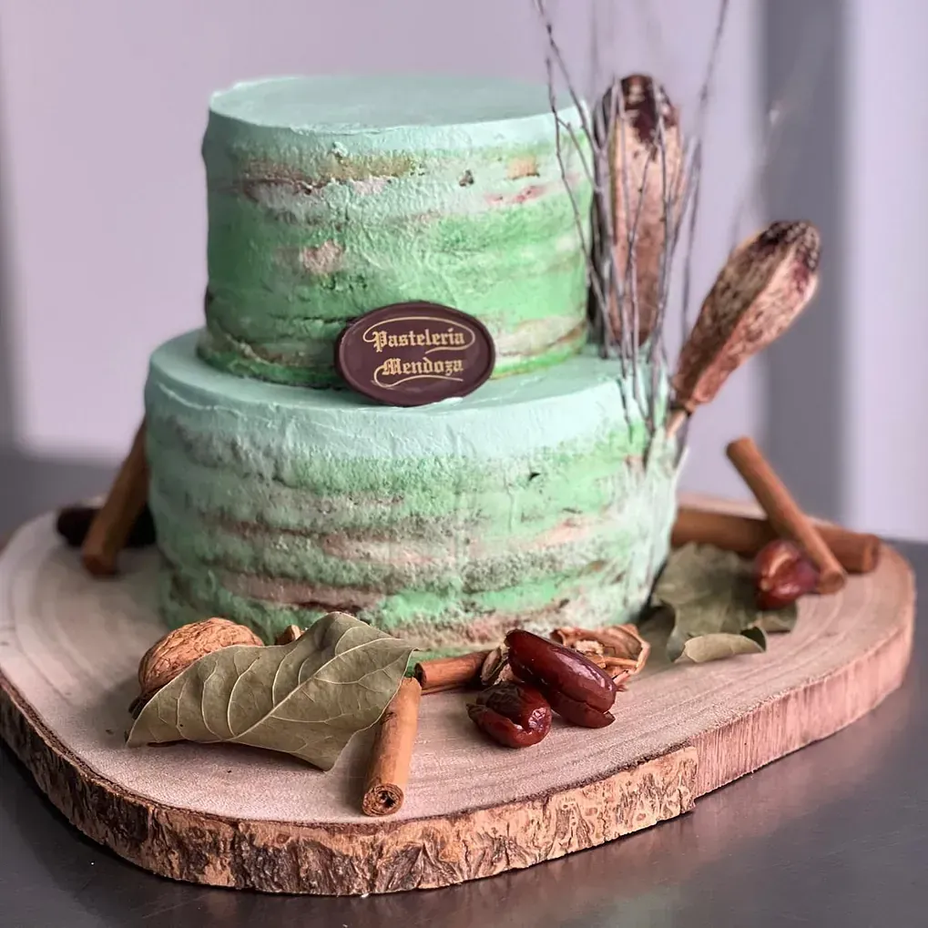 Un pastel verde reposa sobre una tabla de cortar de madera.