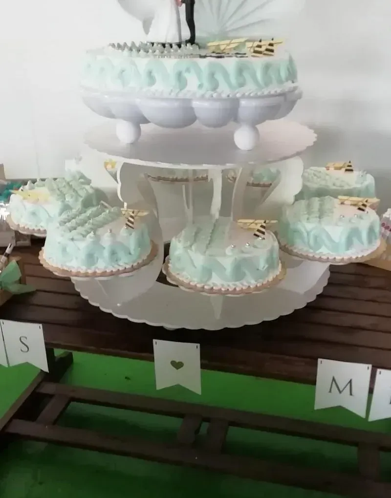 Un soporte para pasteles con un pastel de novios encima