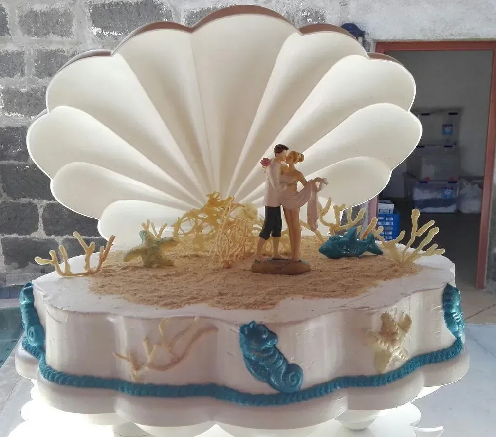 Un pastel de bodas con una figura de novios en la parte superior.
