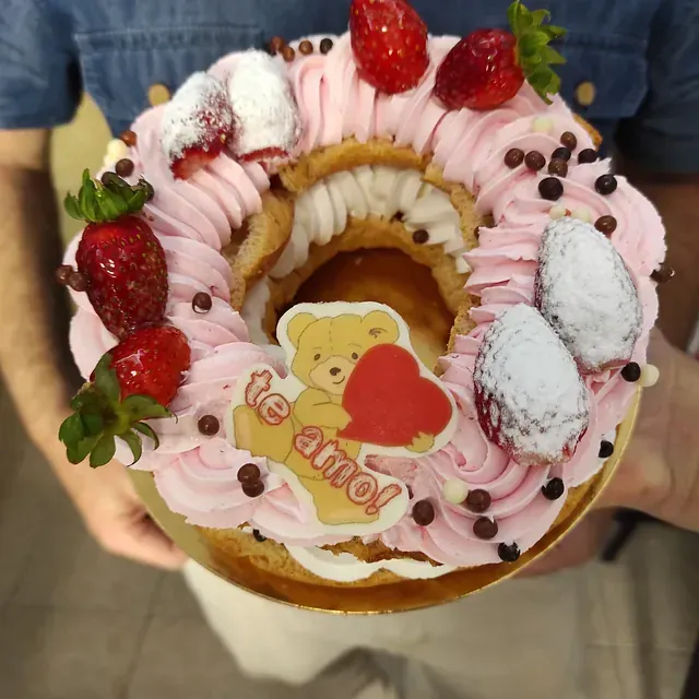 Una persona sostiene un pastel que dice te amo