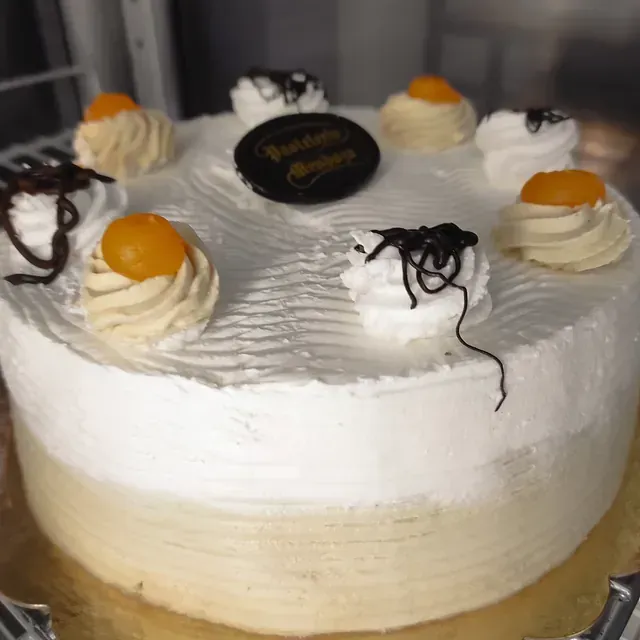 Un pastel con crema batida y rodajas de naranja encima.