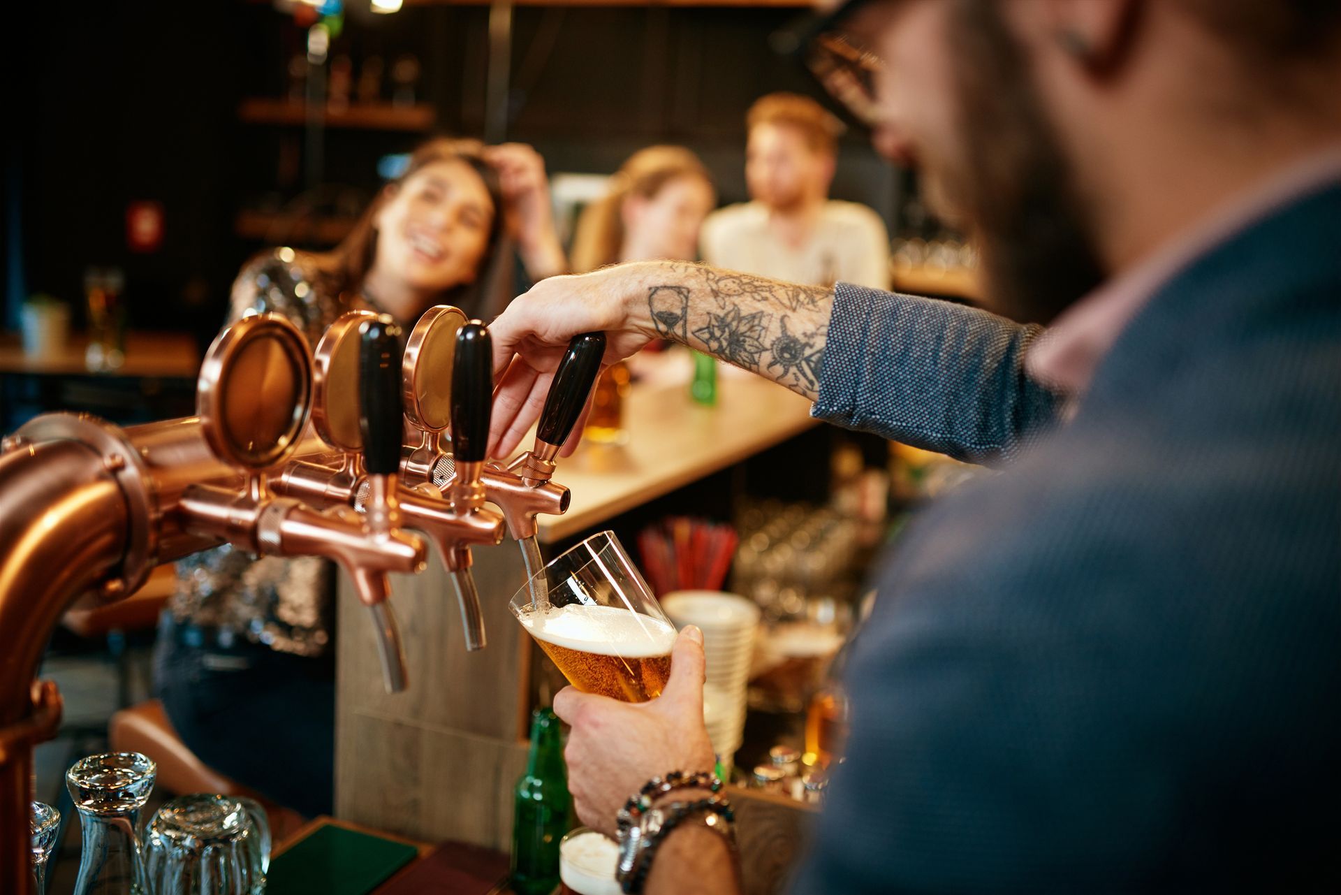A man is pouring beer into a glass at a bar.