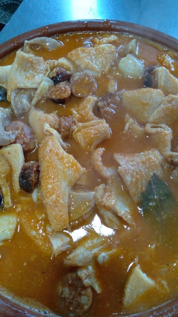Un primer plano de un plato de sopa con carne y verduras sobre una mesa.