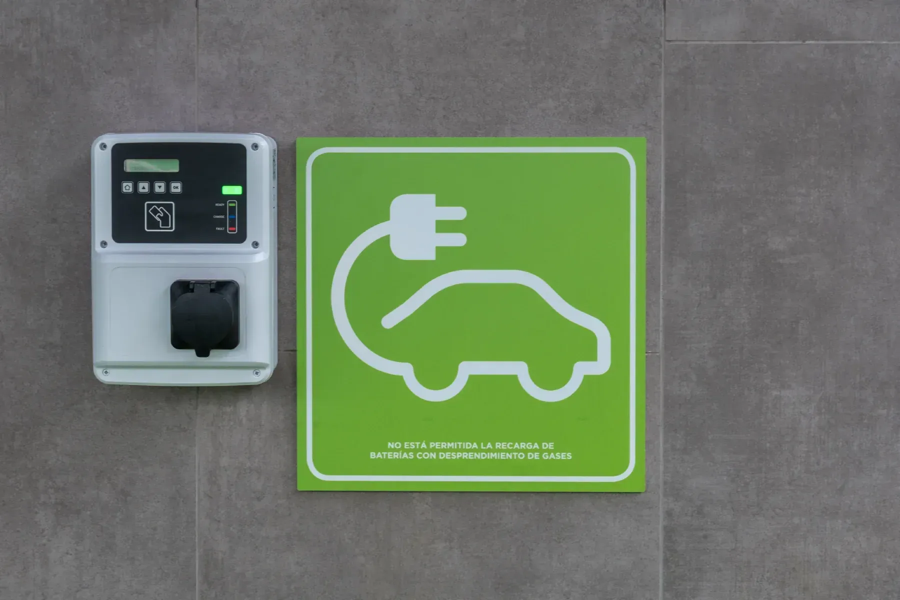 Mano en un guante amarillo y azul trabajando en el cableado eléctrico en un panel.