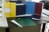 Un escritorio con un montón de libros encima y un teclado.