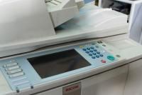 Una impresora blanca con una pantalla grande está encima de una mesa.