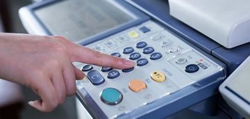 Una persona está presionando un botón en una impresora.