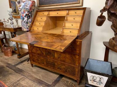 Scrivania in legno con piano inclinato, aperto, che rivela piccoli cassetti e scomparti; pavimento in legno.