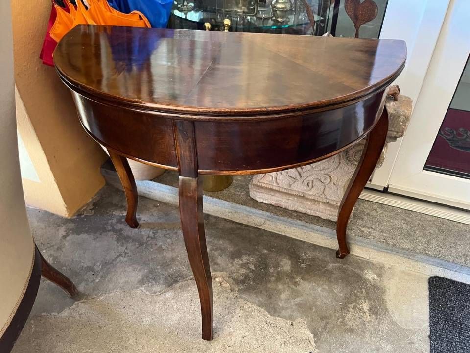 Scultura in legno raffigurante un uomo con turbante che regge un vaso e tiene le braccia tese su un piedistallo.