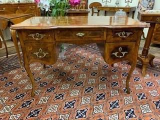 Scrivania in legno con piano inclinato, aperto, che rivela piccoli cassetti e scomparti; pavimento in legno.