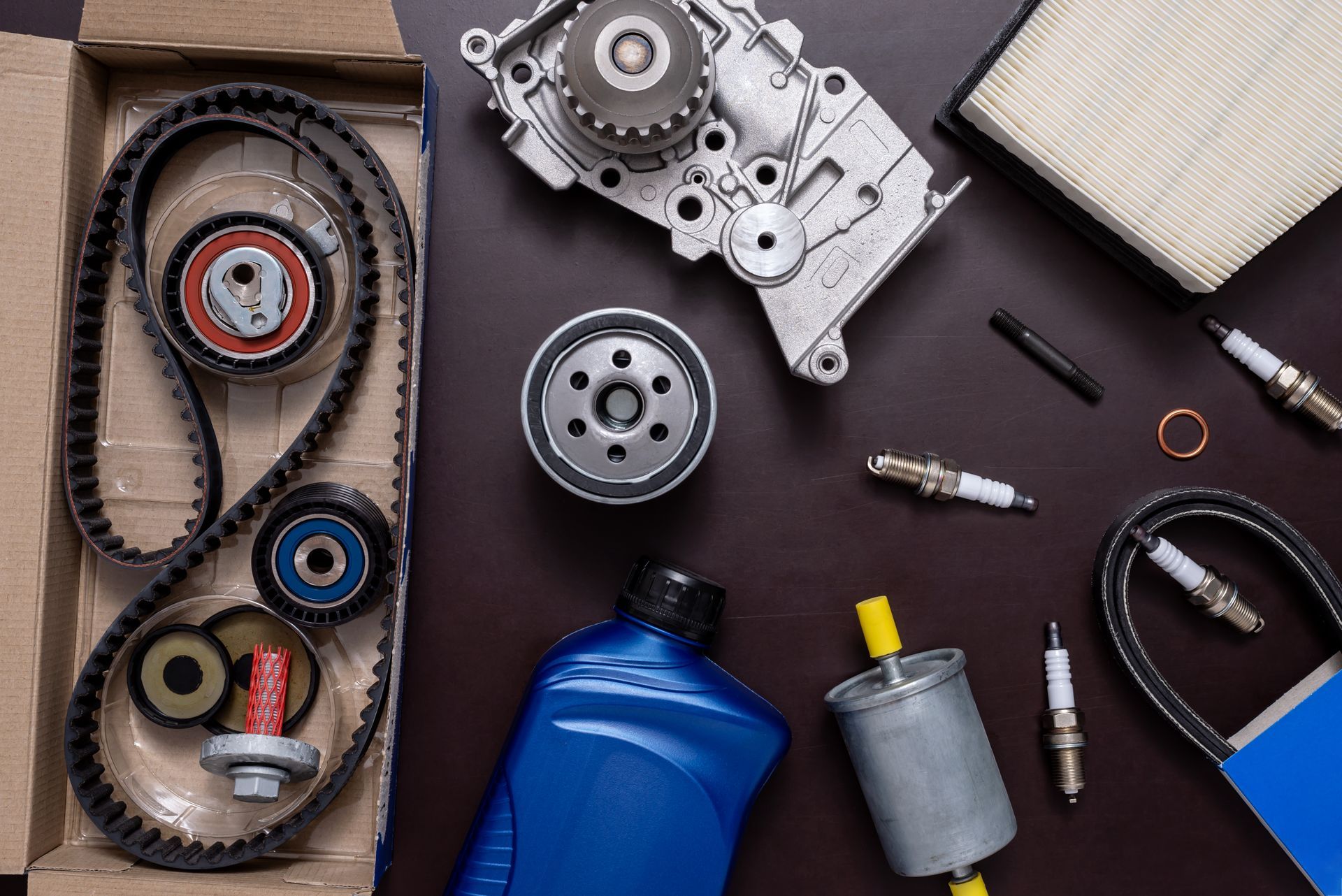 Un assortiment de pièces d'entretien automobile, comprenant une courroie de distribution, un filtre à huile, des bougies d'allumage et un filtre à carburant.