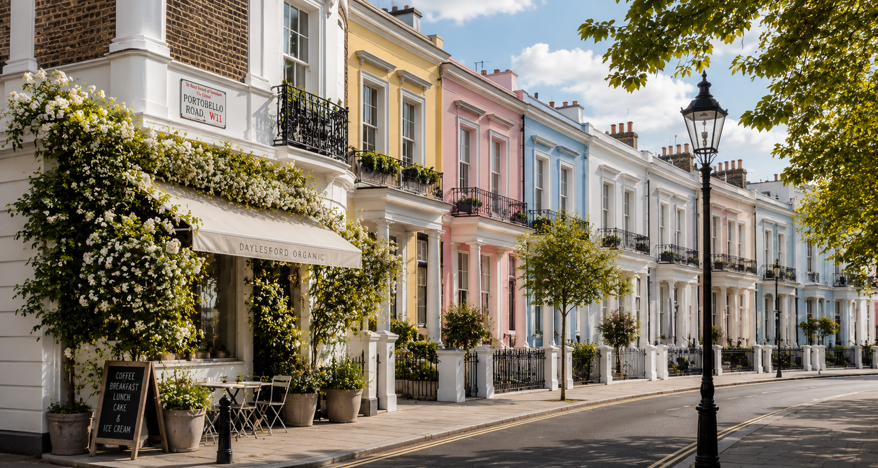 Pastel townhouses with awnings and potted plants on a quiet, sunlit street