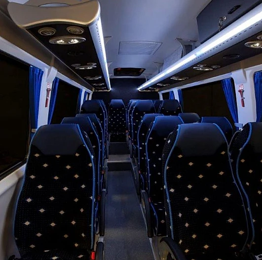 El interior de un autobús con muchos asientos azules.