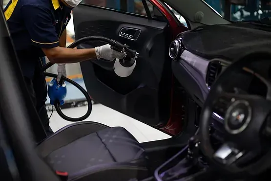 Un hombre está limpiando el interior de un coche.
