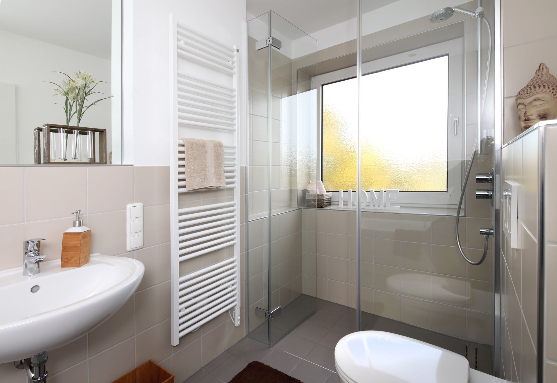 Salle de bains avec une douche à l'italienne, un sèche-serviettes et un lavabo.