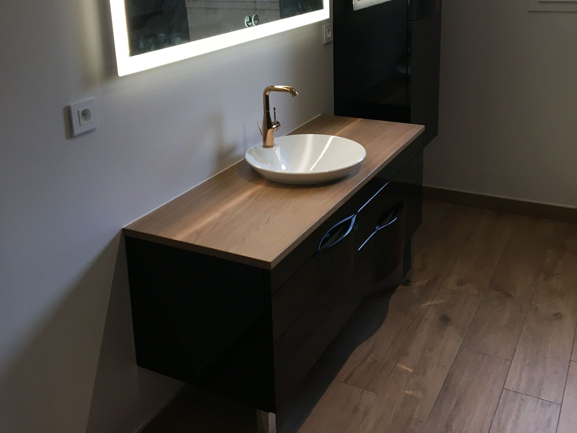 Meuble de salle de bains avec une vasque et un robinet.