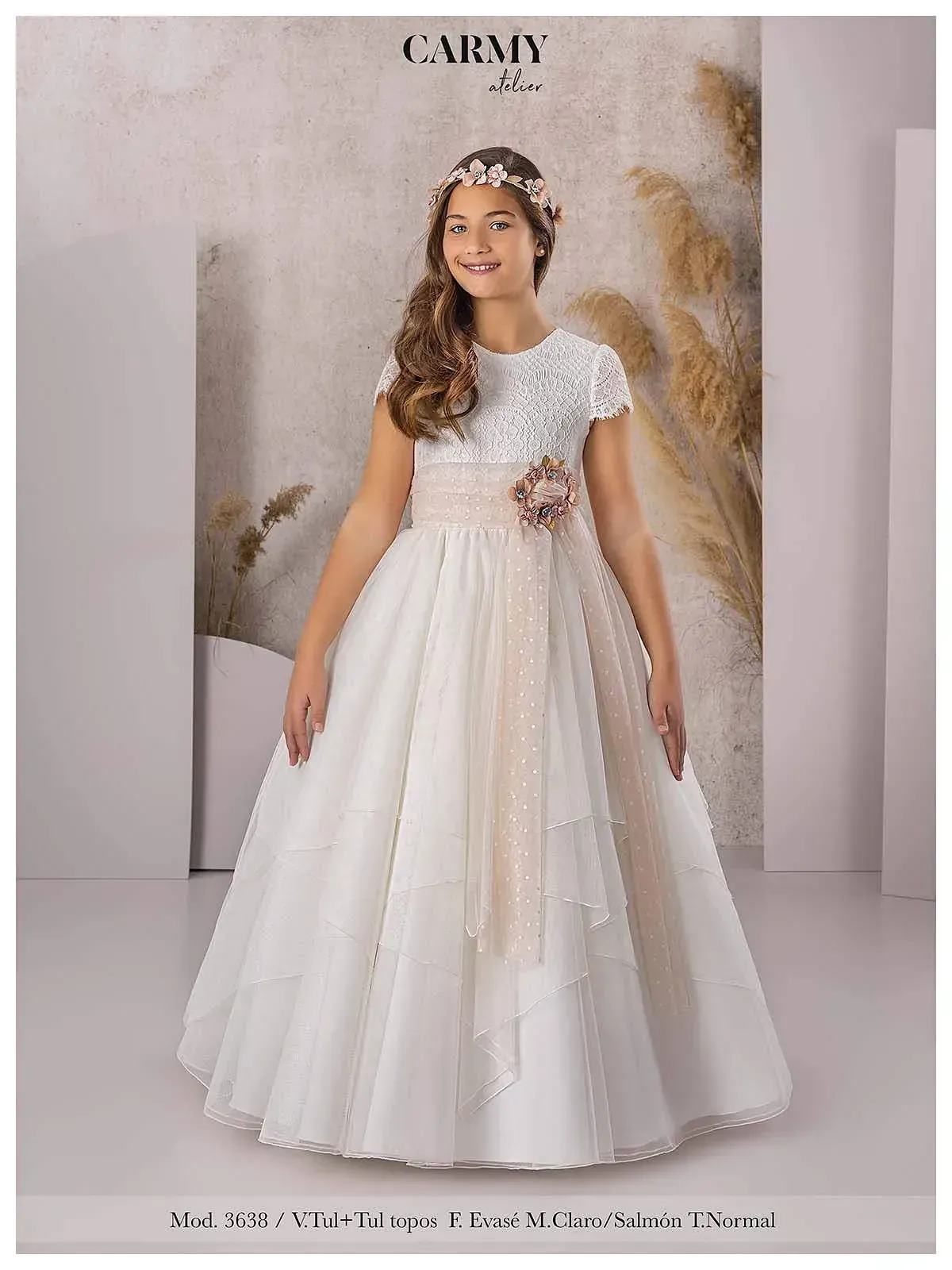 Una niña lleva un vestido blanco y una corona de flores.