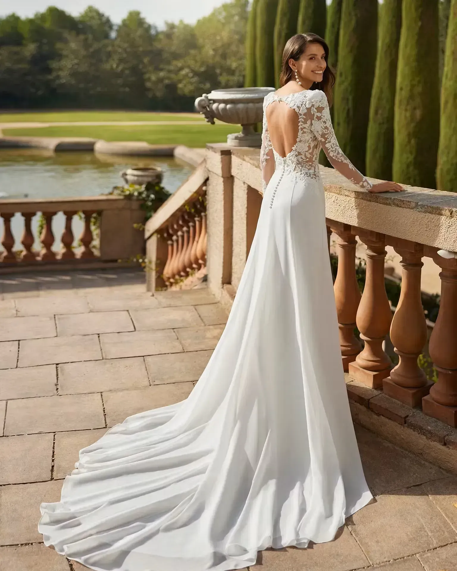 Una mujer con un vestido de novia blanco está de pie junto a una barandilla.