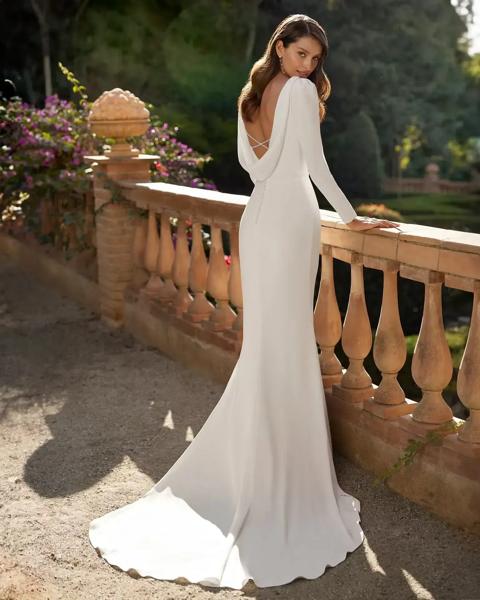 Una mujer con un vestido blanco está de pie junto a una barandilla.