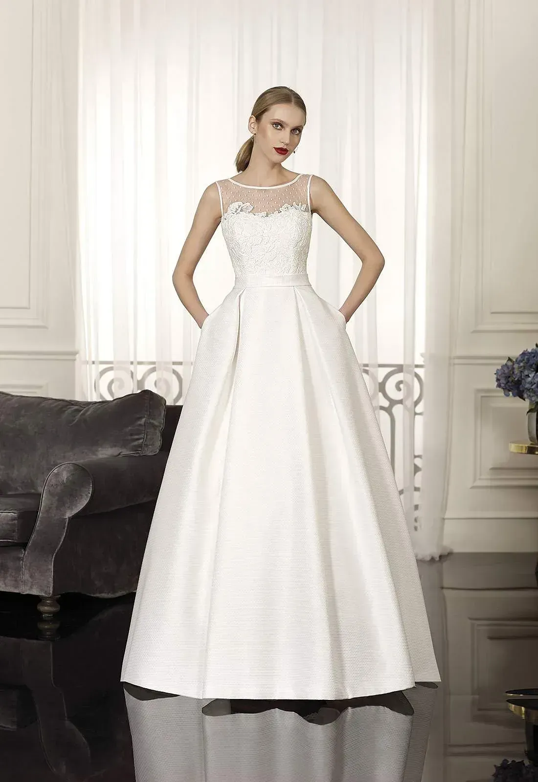 Una mujer lleva un vestido de novia blanco en una sala de estar.
